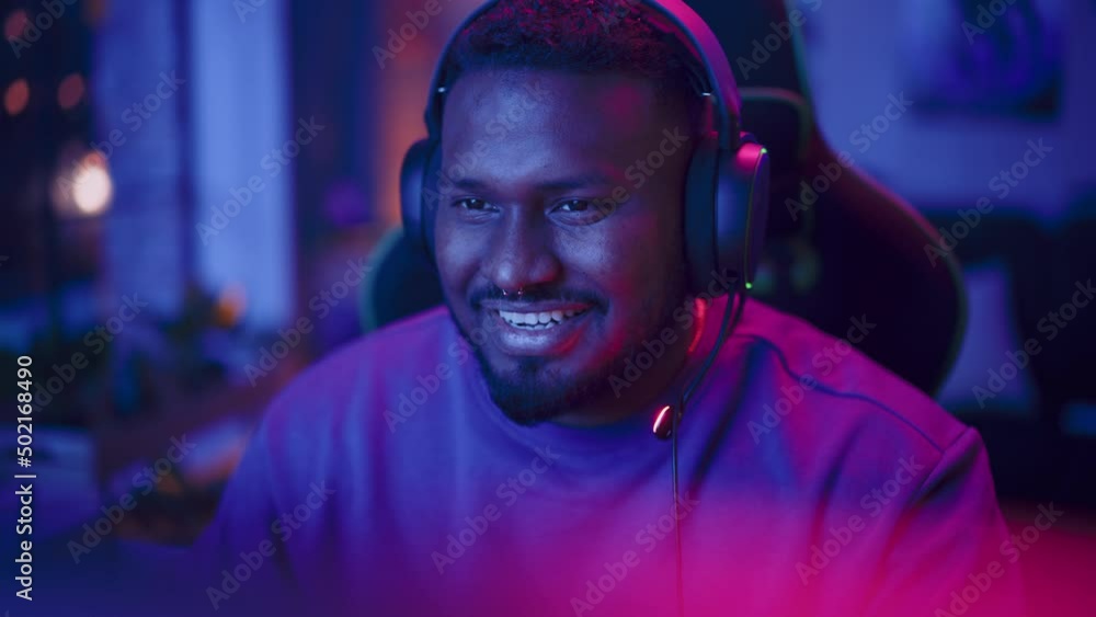 Professional Multiethnic Gamer Playing Online Video Game on Computer. Close Up Portrait of Young Black Man in Headphones Battling in PvP Tournament with Other Players, Talking with Team on Microphone. Professional Multiethnic Gamer Playing Online Video Game on Computer. Close Up Portrait of Young Black Man in Headphones Battling in PvP Tournament with Other Players, Talking with Team on Microphone.