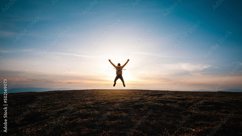 Happy man with open arms jumping on the top of mountain - Hiker with backpack celebrating success outdoor - People, success and sport concept Happy man with open arms jumping on the top of mountain - Hiker with backpack celebrating success outdoor - People, success and sport concept