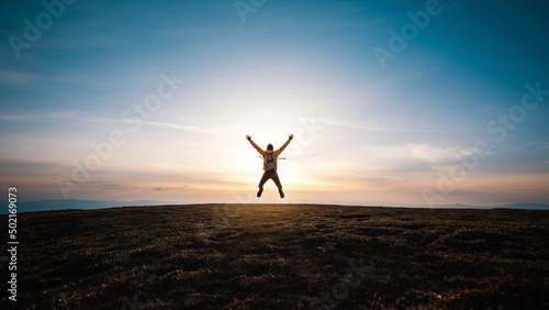 Happy man with open arms jumping on the top of mountain - Hiker with backpack celebrating success outdoor - People  success and sport concept