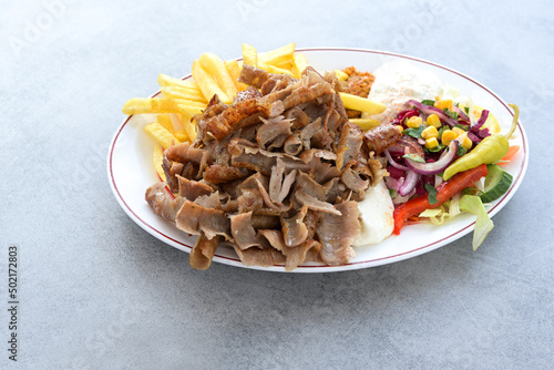 Carta da parati Thin slices of doner kebab meat with french fries, salad and yogurt dip sauce on