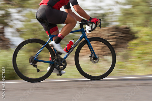 Road bike cyclist man cycling, athlete on a race cycle. Panning technique used