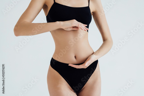 Cropped shot of fit woman's torso woman in bikini isolated on white background. Female with perfect abdomen muscles posing on white background. © F8  \ Suport Ukraine