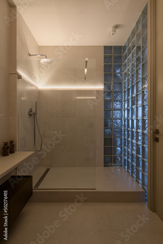 shower in the loft interior with glass blocks, modern loft style bathroom with shower, evening lighting in the interior