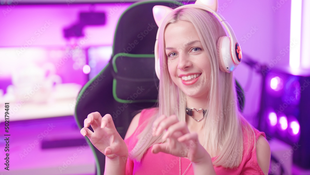 Cute blonde gamer girl kitten with cat ear headphones in cyberspace show her long claws Cute blonde gamer girl kitten with cat ear headphones in cyberspace show her long claws