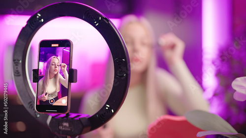 Female make up influencer record eyelashes care tutorial with smartphone photo