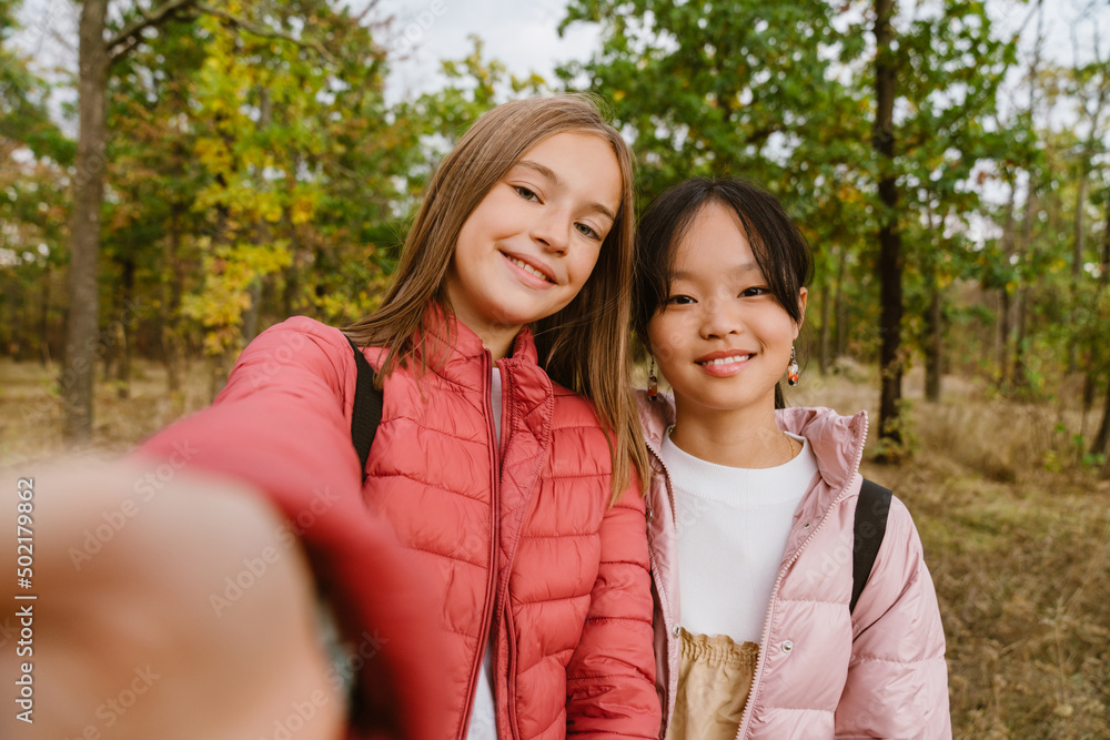 Multiracial teenagers smiling and taking selfie photo during hiking Multiracial teenagers smiling and taking selfie photo during hiking