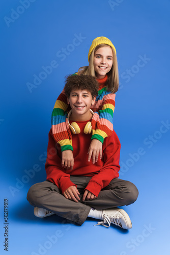 White girl and boy laughing and hugging while posing at camera