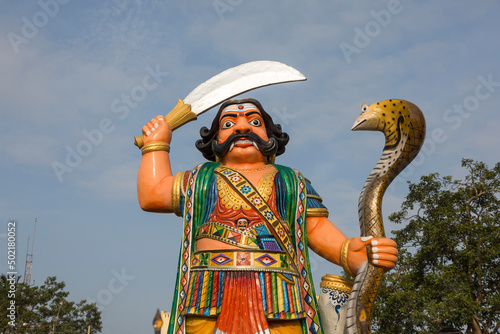 Statue of the mythological Hindu demon Mahishasura at Chamundi Hill in Mysore, India.  The statue of the demon bears a sword in his right hand and a cobra in the left. photo