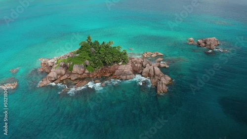 Aerial arc shot around granite uninhabited tiny islet Saint Pierre