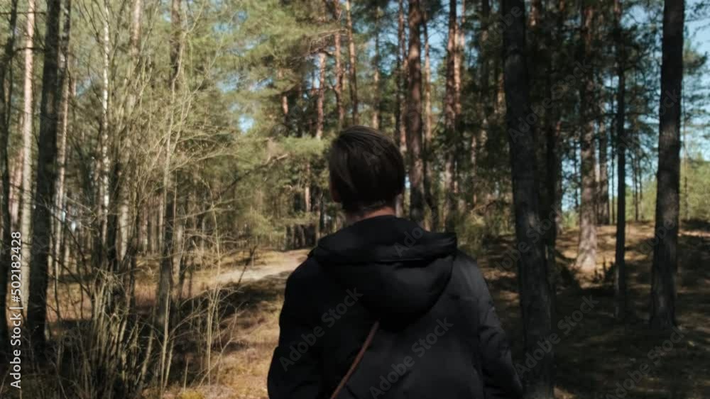A man strolls through a sunny summer forest on a beautiful day. A blond man strolling through the woods. High quality 4k footage A man strolls through a sunny summer forest on a beautiful day. A blond man strolling through the woods. High quality 4k footage