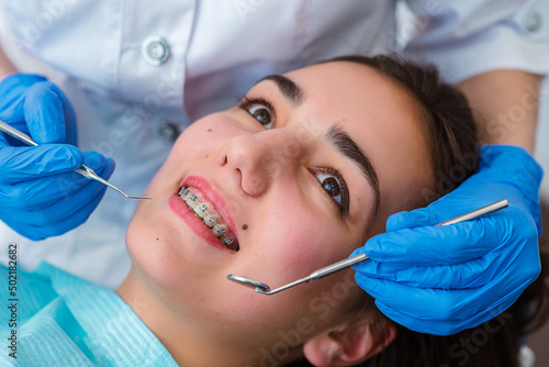 Dentist curing oral cavity of cheerful woman