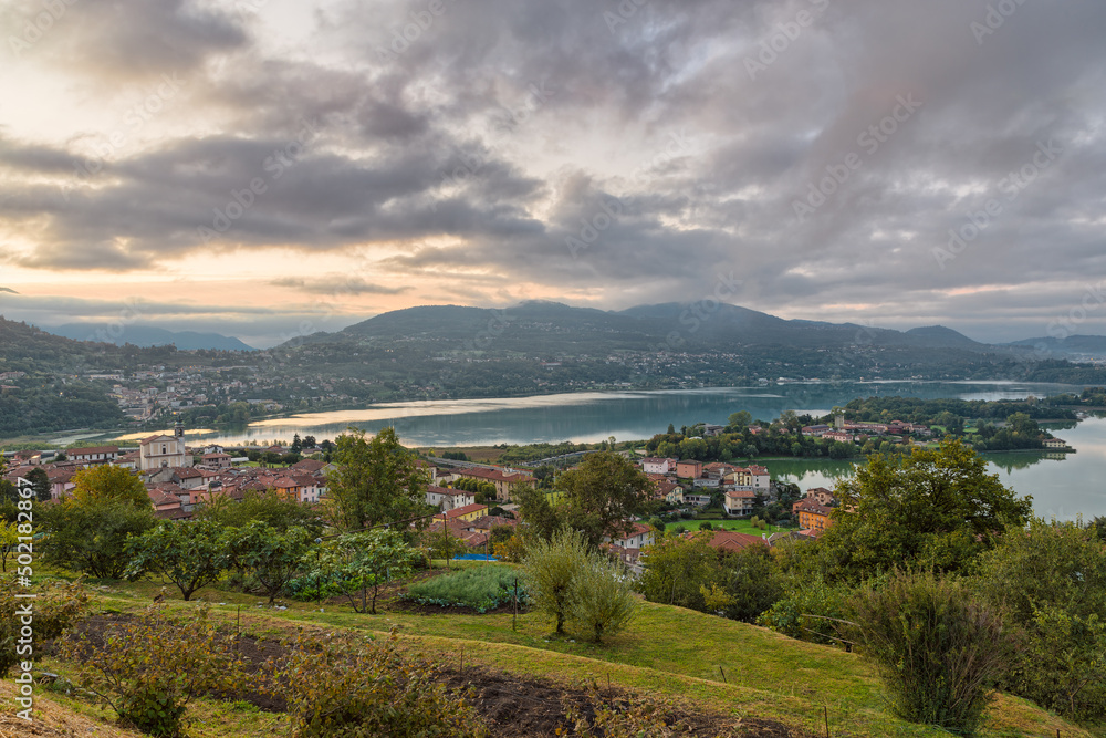 Beautiful Italian lake at sunrise. Aerial view of lake Annone or lake Oggiono with Civate in the foreground and in the background the section between towns of Sala Al Barro and Oggiono