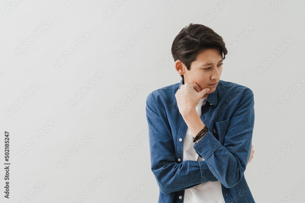 Asian boy wearing shirt posing and looking aside Asian boy wearing shirt posing and looking aside