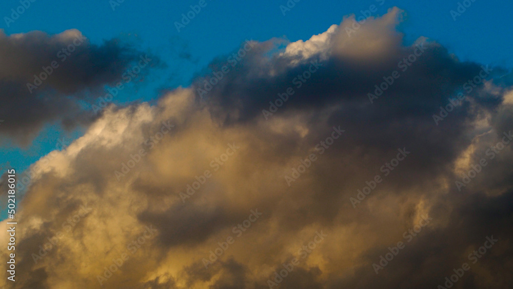 Obraz premium De splendides teintes jaunâtres et orangées magnifient le ciel du crépuscule, sous des petits cumulus