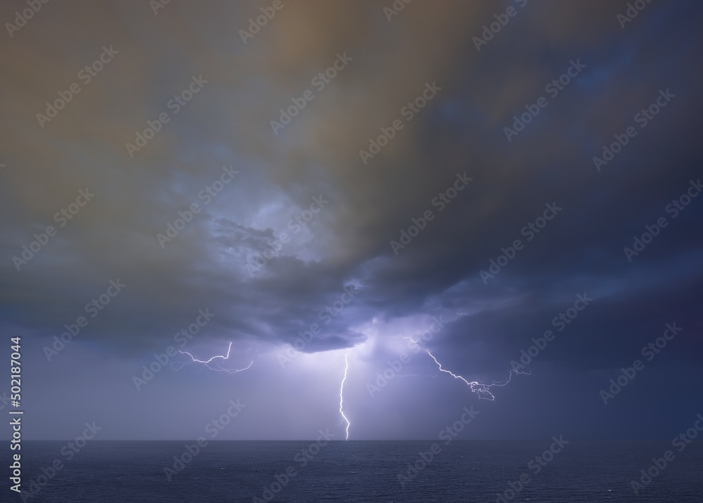 Lightning thunderstorm on stormy dark sky over the sea