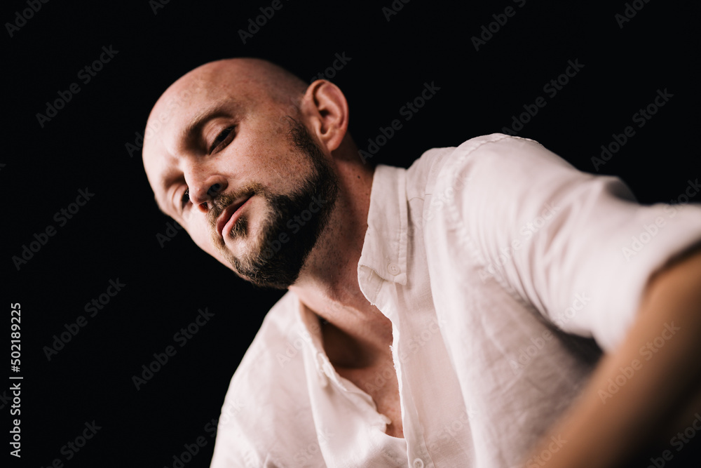 studio portrait of a bald guy with a beautiful beard in a white shirt on a black background studio portrait of a bald guy with a beautiful beard in a white shirt on a black background