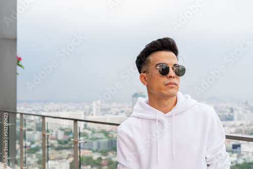 Portrait of handsome young cool man in city wearing sunglasses