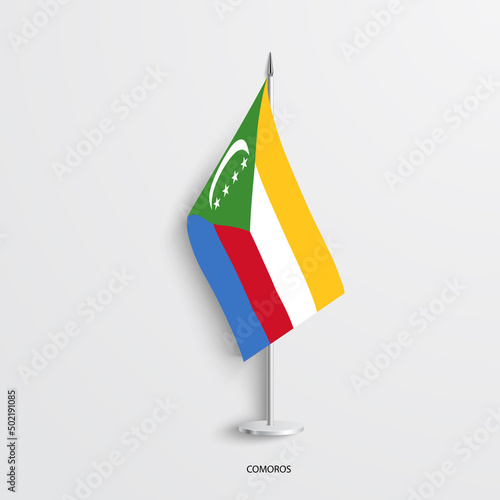 Comoros table flag on light grey background. Comoros desk flag isolated on barely white background.