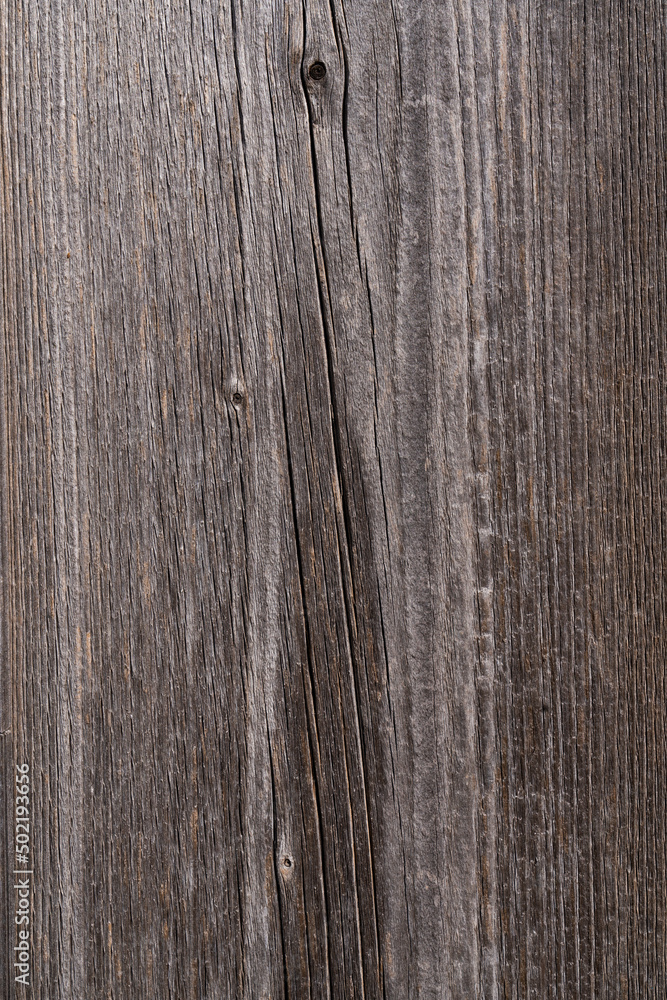 Wooden background gray brown. Wood texture with a fibrous uneven structure, places of knots, cracks. Wooden background gray brown. Wood texture with a fibrous uneven structure, places of knots, cracks.