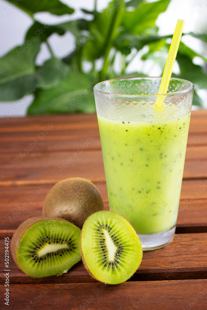 glass cup with kiwi smoothie with kiwi slices on wooden table glass cup with kiwi smoothie with kiwi slices on wooden table