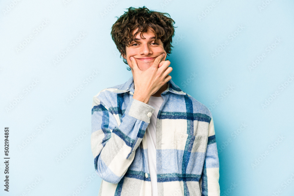 Young caucasian man isolated on blue background doubting between two options. Young caucasian man isolated on blue background doubting between two options.