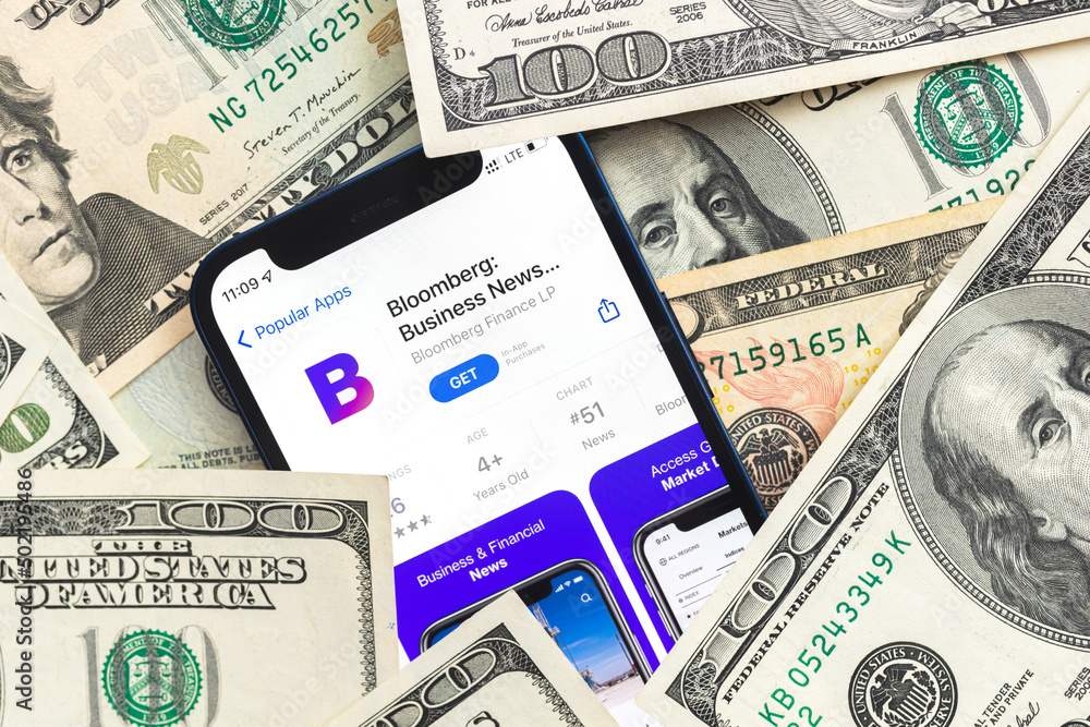 Bloomberg mobile application, business background with dollar banknotes ...
