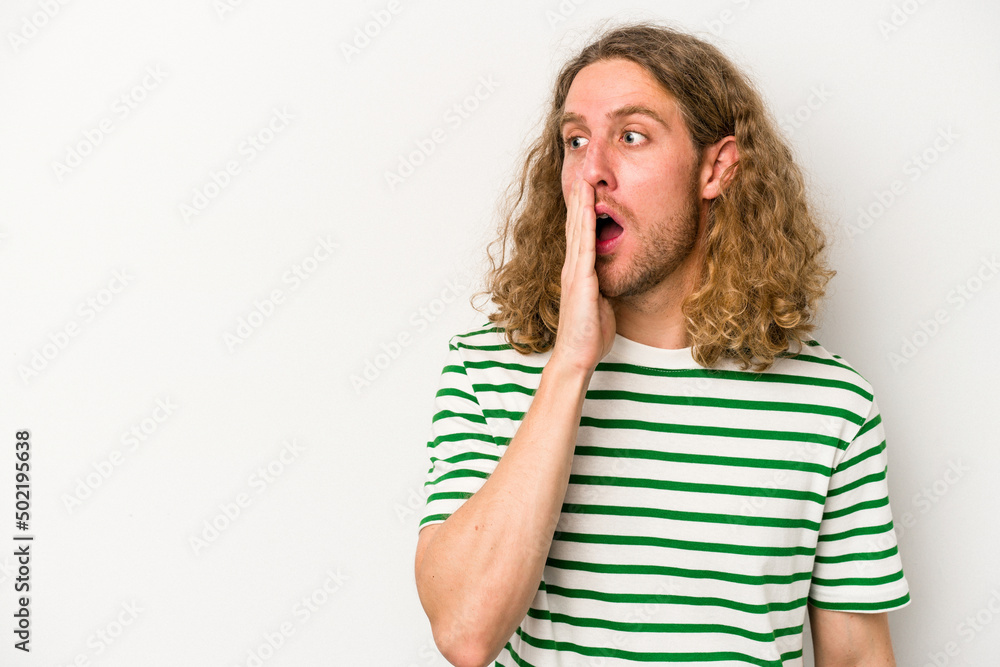 Young caucasian man isolated on white background is saying a secret hot braking news and looking aside Young caucasian man isolated on white background is saying a secret hot braking news and looking aside