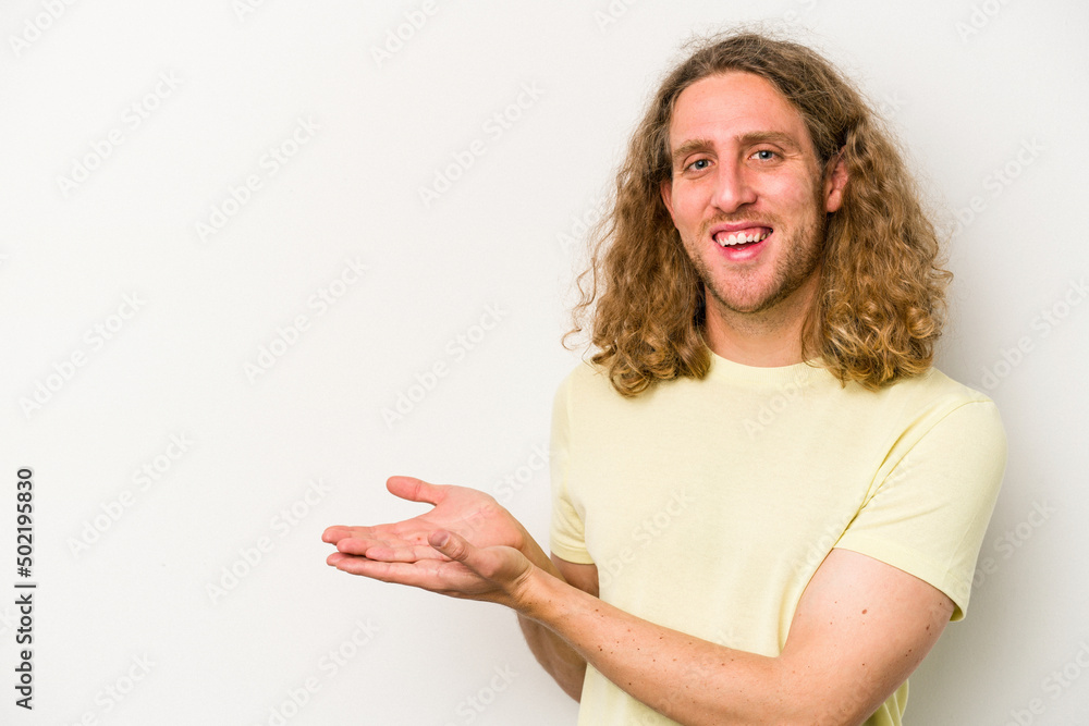 Young caucasian man isolated on white background holding a copy space on a palm. Young caucasian man isolated on white background holding a copy space on a palm.