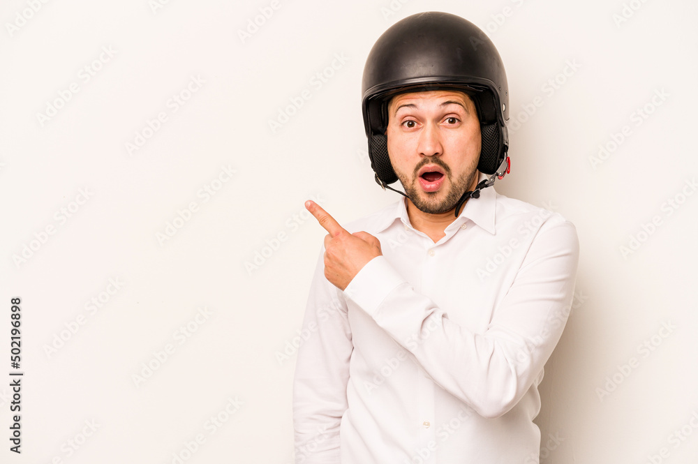 Hispanic business man going to work with motorcycle isolated on white background pointing to the side Hispanic business man going to work with motorcycle isolated on white background pointing to the side