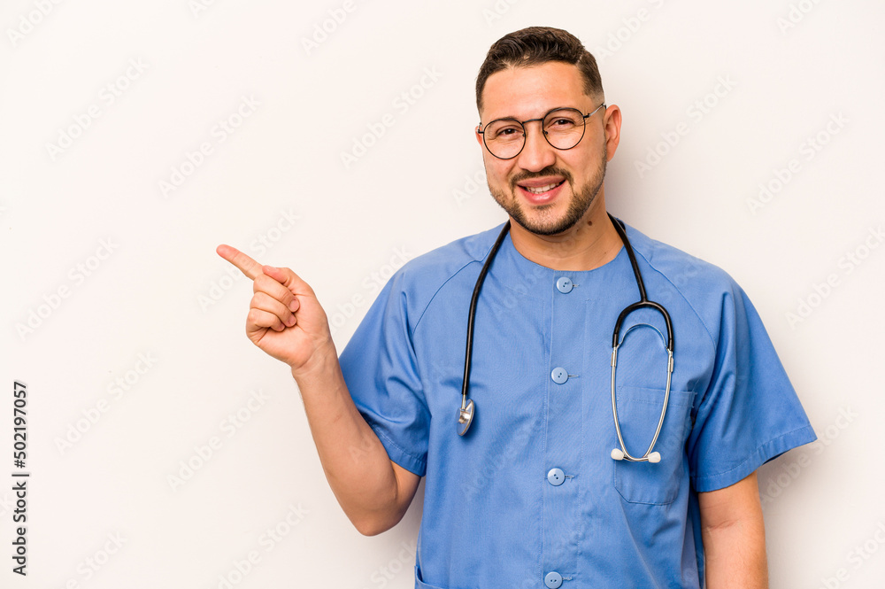 Hispanic nurse man isolated on white background smiling and pointing aside, showing something at blank space. Hispanic nurse man isolated on white background smiling and pointing aside, showing something at blank space.