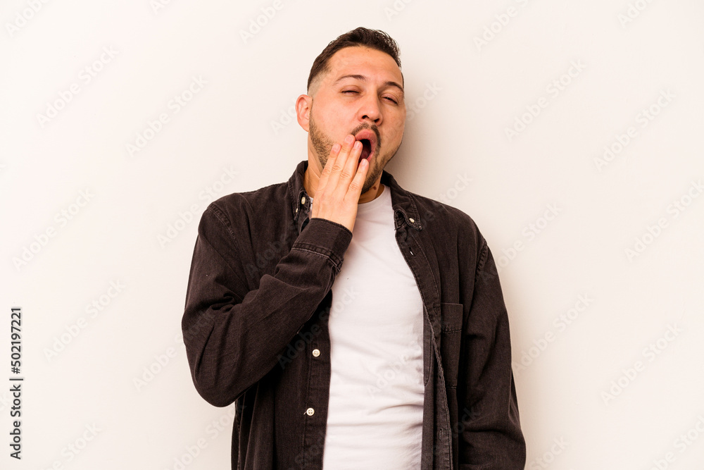 Young hispanic man isolated on white background yawning showing a tired gesture covering mouth with hand. Young hispanic man isolated on white background yawning showing a tired gesture covering mouth with hand.