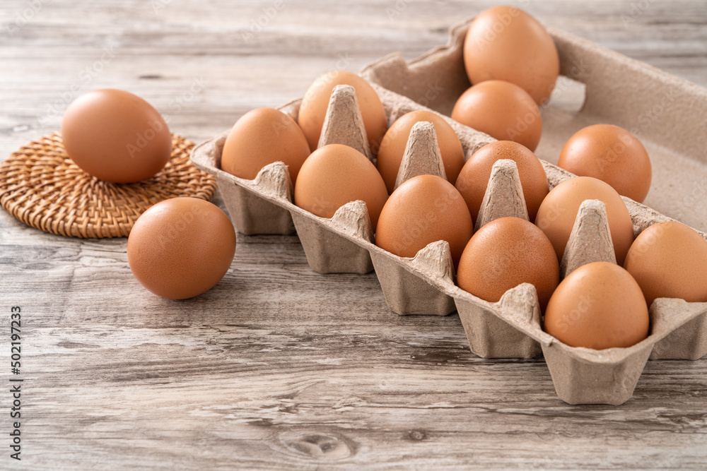 Fresh brown chicken eggs in a kraft paper egg carton. Fresh brown chicken eggs in a kraft paper egg carton.