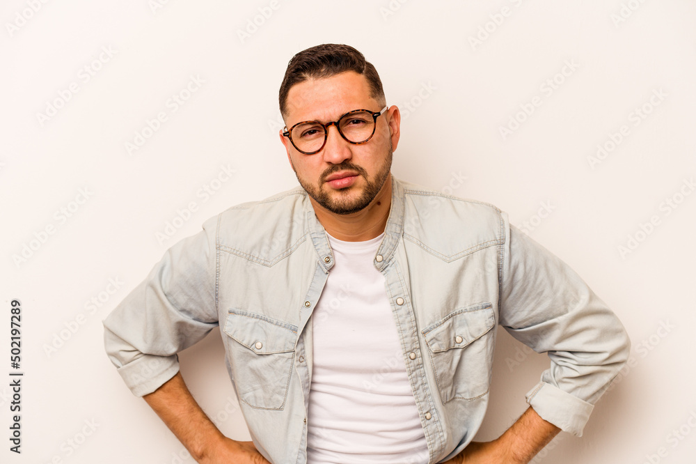 Fototapeta premium Young hispanic man isolated on white background sad, serious face, feeling miserable and displeased.