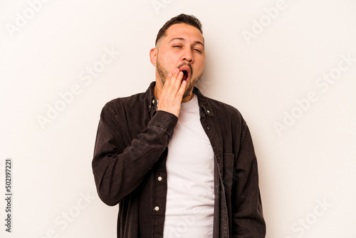 Young hispanic man isolated on white background yawning showing a tired gesture covering mouth with hand.