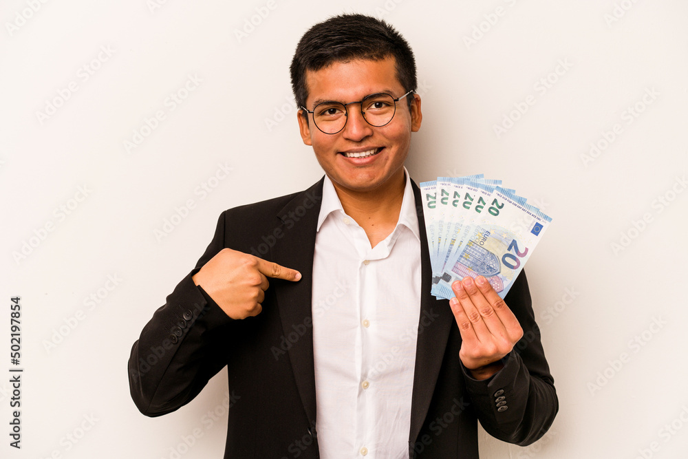 Young hispanic business man holding banknotes isolated on white background person pointing by hand to a shirt copy space, proud and confident Young hispanic business man holding banknotes isolated on white background person pointing by hand to a shirt copy space, proud and confident