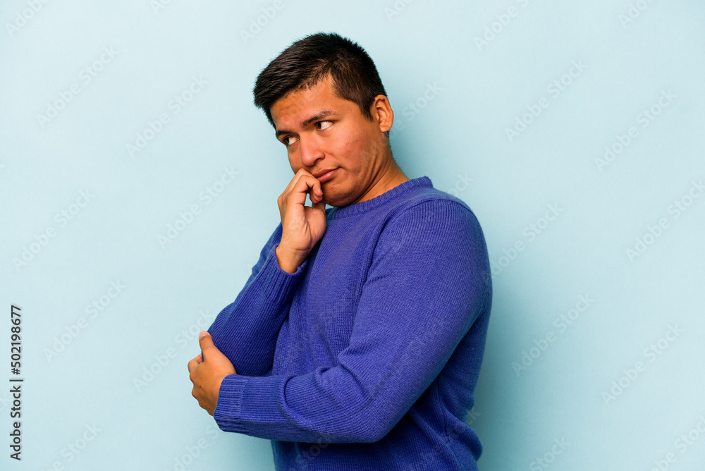 Young hispanic man isolated on blue background confused, feels doubtful and unsure. Young hispanic man isolated on blue background confused, feels doubtful and unsure.