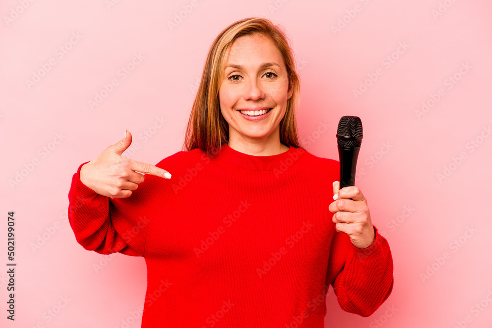 Young caucasian singer woman isolated on pink background person pointing by hand to a shirt copy space, proud and confident Young caucasian singer woman isolated on pink background person pointing by hand to a shirt copy space, proud and confident
