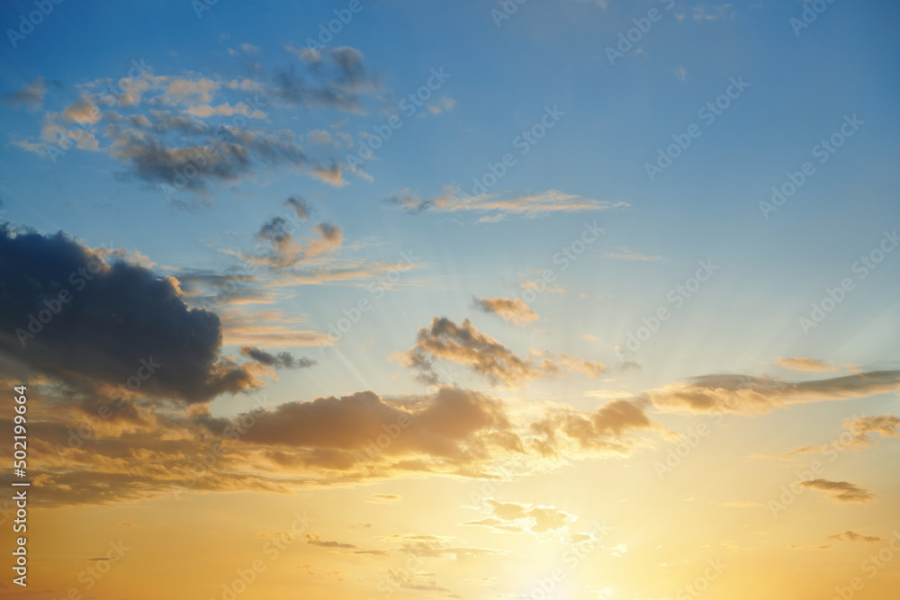 Beautiful sunset with cloudy sky and sun rays. Golden sunset. Sun rays and clouds on evening sky. Sunset scene. Beautiful summer landscape.