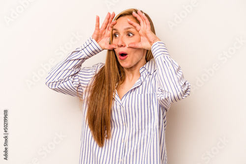 Young caucasian woman isolated on white background keeping eyes opened to find a success opportunity. photo