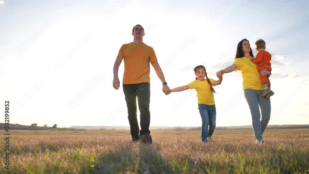 people in the park. happy family silhouette walk at sunset. mom dad and daughters walk holding hands in the park. happy family kid dream concept. parents and fun children walking back silhouette fun people in the park. happy family silhouette walk at sunset. mom dad and daughters walk holding hands in the park. happy family kid dream concept. parents and fun children walking back silhouette fun