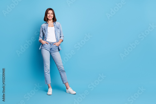 Photo of cute adorable lady dressed denim shirt walking empty space isolated blue color background