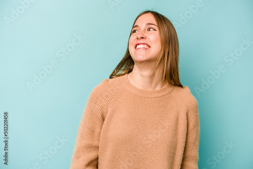 Young caucasian woman isolated on blue background relaxed and happy laughing, neck stretched showing teeth.