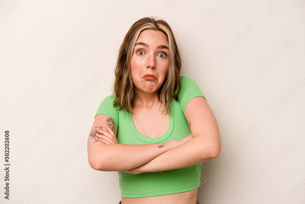 Young caucasian woman isolated on white background shrugs shoulders and open eyes confused. Young caucasian woman isolated on white background shrugs shoulders and open eyes confused.
