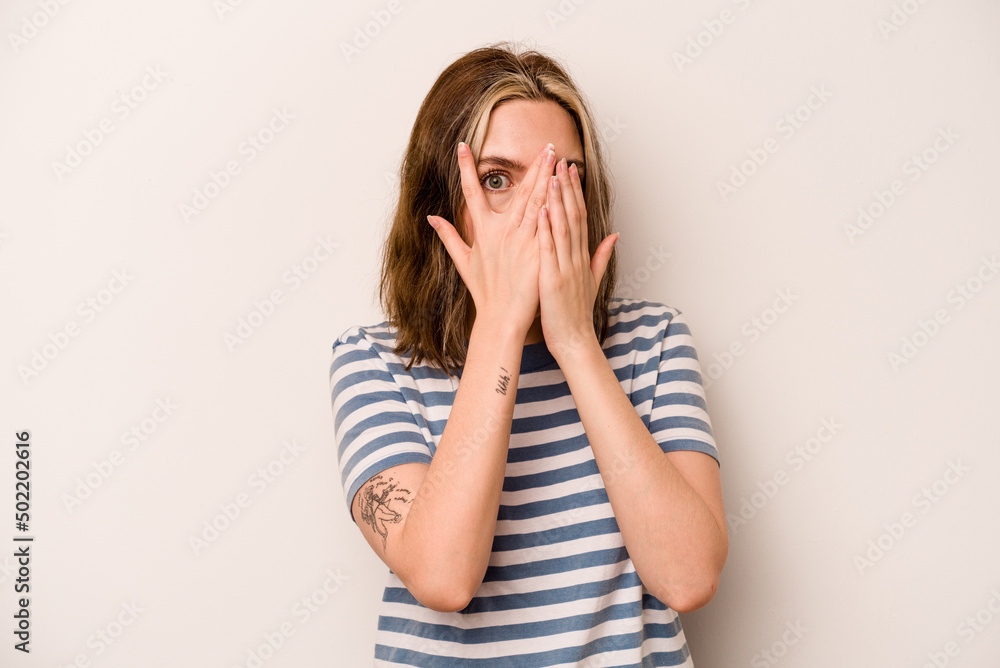 Young caucasian woman isolated on white background blink through fingers frightened and nervous. Young caucasian woman isolated on white background blink through fingers frightened and nervous.