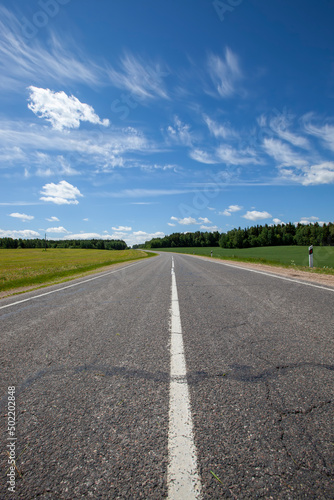 paved highway with blue sky and clouds