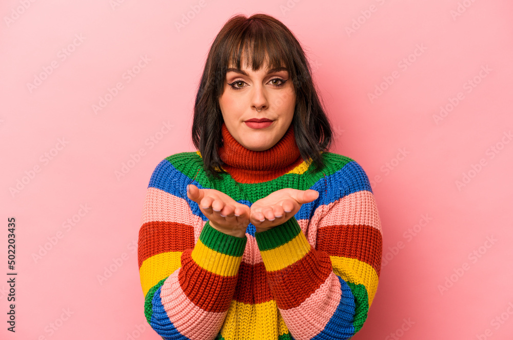 Young caucasian woman isolated on pink background holding something with palms, offering to camera. Young caucasian woman isolated on pink background holding something with palms, offering to camera.