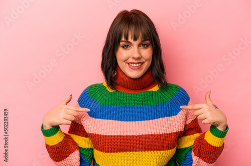 Young caucasian woman isolated on pink background points down with fingers, positive feeling.