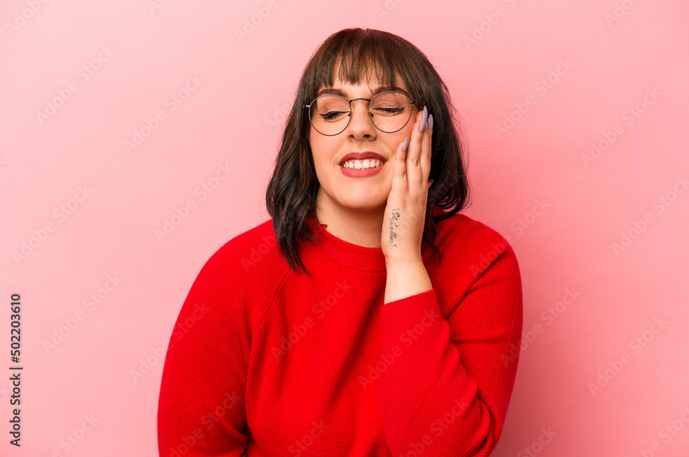 Young caucasian woman isolated on pink background laughs happily and has fun keeping hands on stomach. Young caucasian woman isolated on pink background laughs happily and has fun keeping hands on stomach.