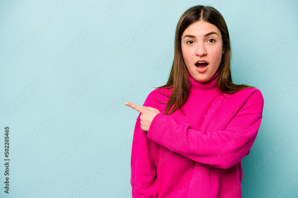 Young caucasian woman isolated on blue background pointing to the side Young caucasian woman isolated on blue background pointing to the side