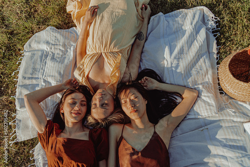 Top view of a group of happy girls lying on a meadow. photo